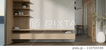 A modern wooden TV cabinet against the white empty wall in a modern contemporary living room. 110704599