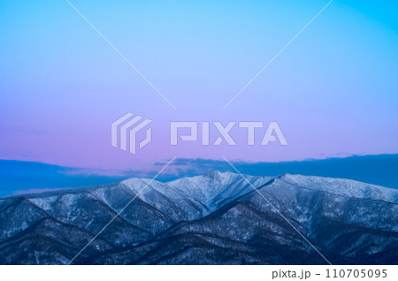 鮮やかな夜明けのグラデーションの空と雪山。 鮮やかな夜明けのグラデーションの空と雪山。 110705095