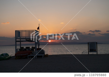 沖縄北部の海岸線に沈む夕日 110705660
