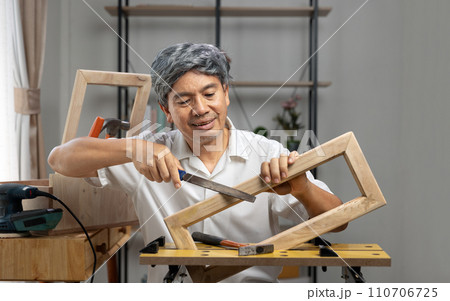 Woodworking hobby after Retirement. Senior man made a parts of woodwork  at home. 110706725