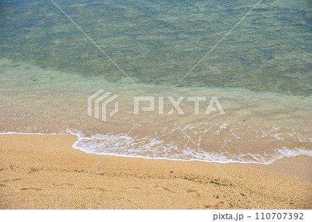 透明でエメラルドグリーンが綺麗な沖縄の波打ち際の風景 110707392