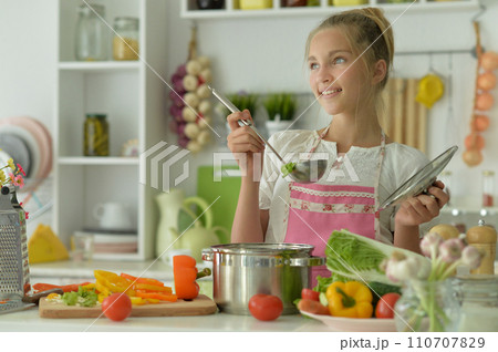 Portrait of a beautiful girl preparing a salad in the kitchen 110707829