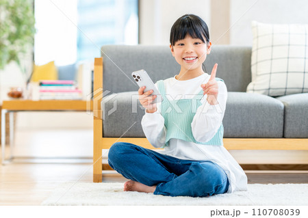 スマホを操作する小学生の女の子。 スマホを操作する小学生の女の子。 110708039