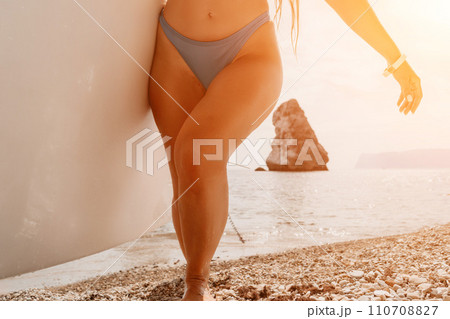 Woman sea sup. Close up portrait of happy young caucasian woman with long hair looking at camera and smiling. Cute woman portrait in bikini posing on sup board in the sea Woman sea sup. Close up portrait of happy young caucasian woman with long hair looking at camera and smiling. Cute woman portrait in bikini posing on sup board in the sea 110708827