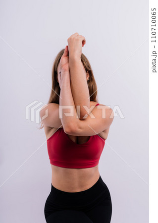 Beautiful woman doing Lotus of Padmasana or Kamalasana pose on yoga class. Studio shot. 110710065
