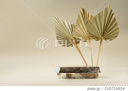 Granite stones on a beige background with golden leaves Granite stones on a beige background with golden leaves 110710824