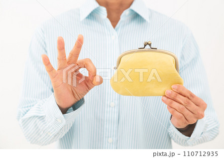 がま口財布を持って丸サインをするミドル女性 110712935