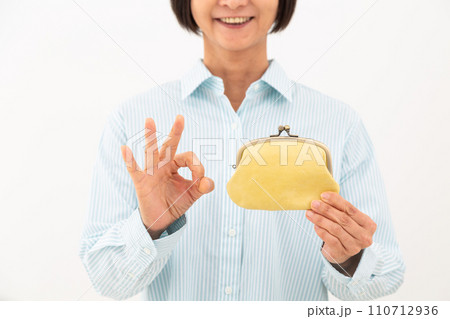 がま口財布を持って丸サインをするミドル女性 110712936