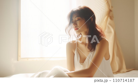 ベッドの上で体調不良の女性 110714187