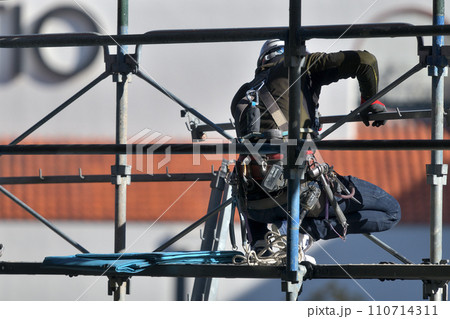 工事現場　塗装工事の仮設足場組み立て　とび職人の作業風景 110714311