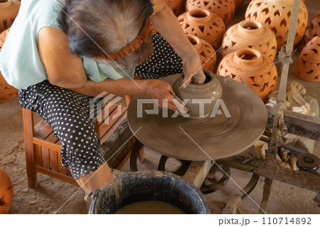 Earthenware earthen pot or a clay pot bowl. Traditional old local woman. People lifestyle. Earthenware earthen pot or a clay pot bowl. Traditional old local woman. People lifestyle. 110714892