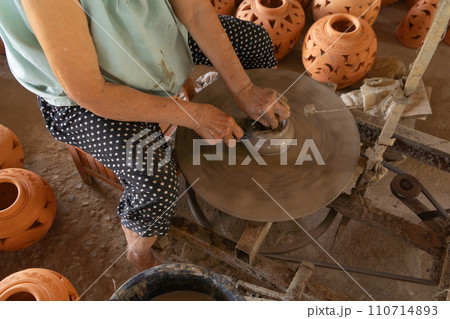 Earthenware earthen pot or a clay pot bowl. Traditional old local woman. People lifestyle. 110714893