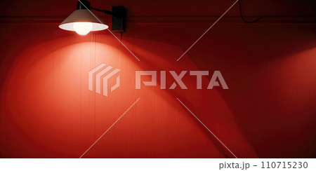 Illuminated Light Hanging Against red Wall. hanged ceiling lamp warm tone light color bulb light with dark red tone concrete background wall 110715230