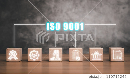 ISO 9001 concept, Wooden block on desk with iso 9001 icon on virtual screen. 110715243
