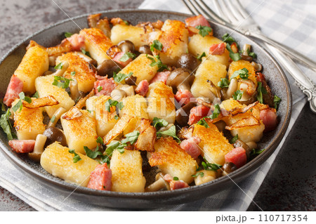 Homemade traditional Polish potato dumplings kopytka served with bacon, onions and mushrooms close-up in a plate. Horizontal Homemade traditional Polish potato dumplings kopytka served with bacon, onions and mushrooms close-up in a plate. Horizontal 110717354
