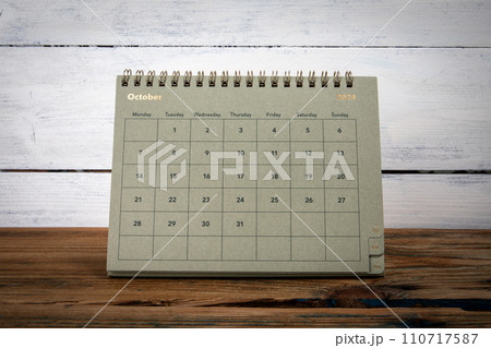 OCTOBER 2024 cardboard desk calendar and planner on a wooden texture table 110717587