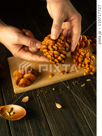The cook hands sorting mushrooms on the kitchen table. Preparing dietary Armillaria mellea for lunch with aromatic spices 110717727