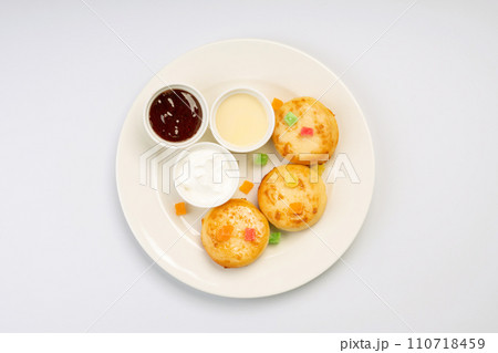 Breakfast. Cheesecakes with sauces and dried fruits on a white plate and a white background. Breakfast. Cheesecakes with sauces and dried fruits on a white plate and a white background. 110718459