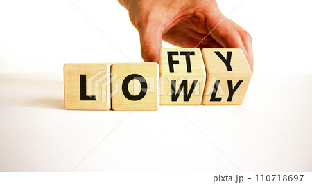 Lofty or lowly symbol. Concept words Lofty Lowly on wooden block. Beautiful white table white background. Businessman hand. Business lofty or lowly concept. Copy space. 110718697