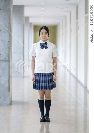 校内の廊下に立つカメラ目線で微笑む女子高校生　全身　撮影協力：有明教育芸術短期大学 110719950