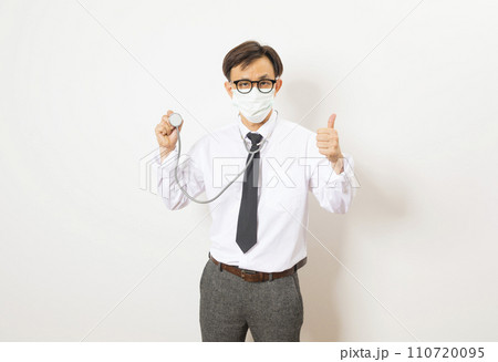Healthcare and medical check up concept. Male Asian doctor holding stethoscope in hand. Physician man wearing surgical mask working in hospital clinic during Coronavirus (COVID-19) pandemic Healthcare and medical check up concept. Male Asian doctor holding stethoscope in hand. Physician man wearing surgical mask working in hospital clinic during Coronavirus (COVID-19) pandemic 110720095