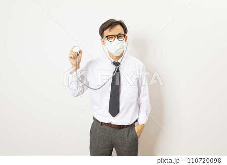 Healthcare and medical check up concept. Male Asian doctor holding stethoscope in hand. Physician man wearing surgical mask working in hospital clinic during Coronavirus (COVID-19) pandemic Healthcare and medical check up concept. Male Asian doctor holding stethoscope in hand. Physician man wearing surgical mask working in hospital clinic during Coronavirus (COVID-19) pandemic 110720098