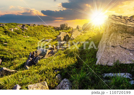 mountain summer landscape at sunset. meadow with huge stones among the grass on top of the hillside. beautiful countryside scenery in evening light 110720199