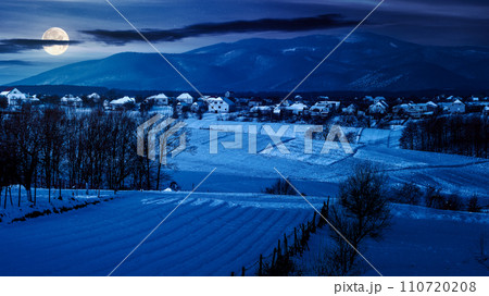 mountainous countryside scenery in winter at night. landscape with snow covered rural fields in full moon light mountainous countryside scenery in winter at night. landscape with snow covered rural fields in full moon light 110720208