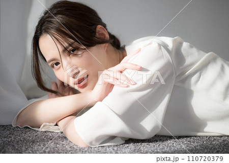 日差しの中美人なけだるい表情（アンニュイ）なおしゃれなカメラ目線の女性 美容やビューティーのイメージ 110720379