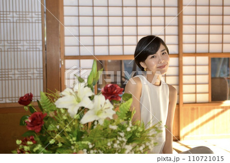 白いワンピースを着た微笑む若い女性 110721015