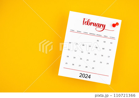 February 2024 calendar page with red push pin on yellow. February 2024 calendar page with red push pin on yellow. 110721366