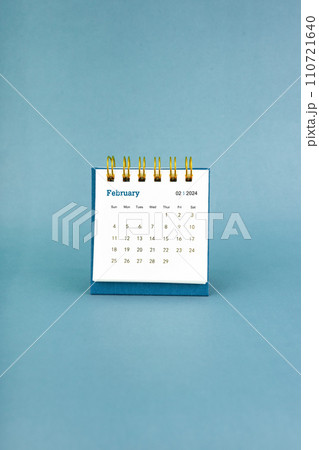 February 2024 white desk calendar on blue color. February 2024 white desk calendar on blue color. 110721640