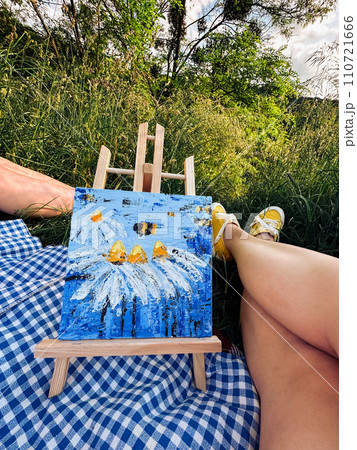 Engaging in artistic pursuits during a picnic in the park. Engaging in artistic pursuits during a picnic in the park. 110721666