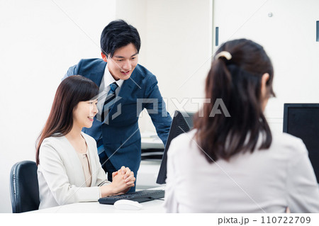 女性上司に報告をする若いビジネスマン 110722709