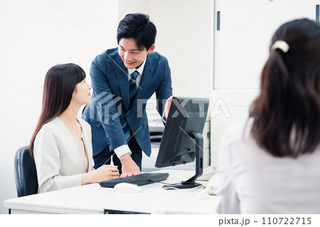 女性上司に報告をする若いビジネスマン 110722715