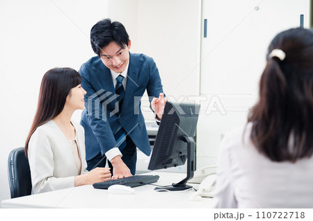 女性上司に報告をする若いビジネスマン 110722718