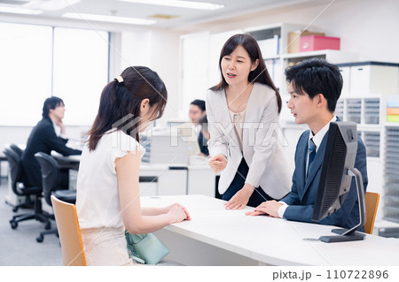 お客様の困った要求に対応をする窓口スタッフ お客様の困った要求に対応をする窓口スタッフ 110722896