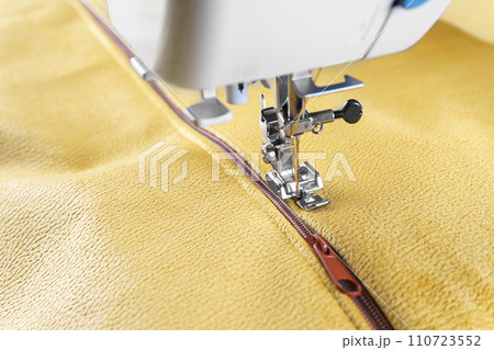Modern sewing machine with yellow velours fabric close up 110723552
