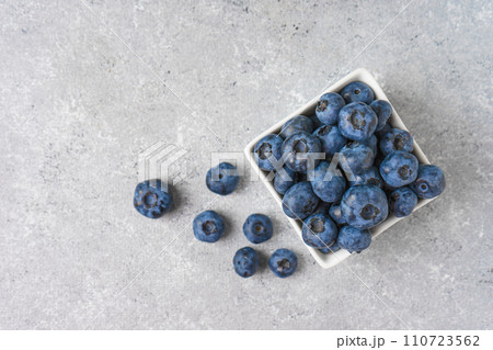 Fresh blueberries in a small square bowl on gray concrete background with copy space 110723562