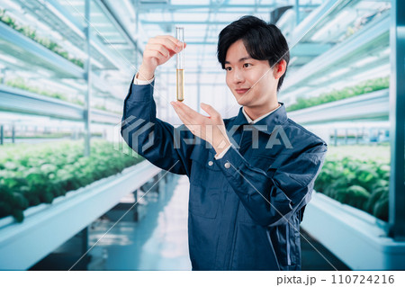 作業服で農薬の研究をする技術者 110724216