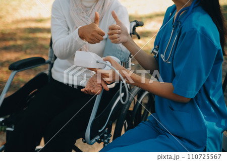 nurse with elderly man in wheelchair at park 110725567