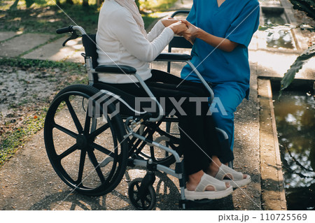 A nurse take care a senior male on wheelchair in his garden at home 110725569