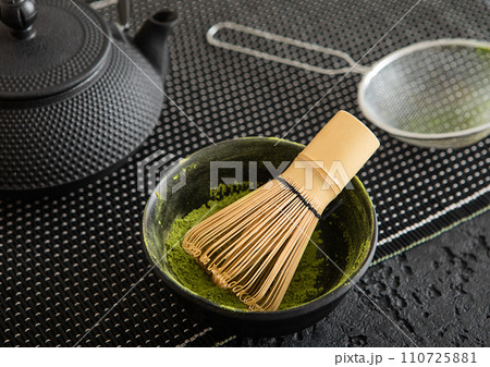 Japanese iron kettle with matcha green tea powder with whisk and spoon and bowl with sifter Japanese iron kettle with matcha green tea powder with whisk and spoon and bowl with sifter 110725881