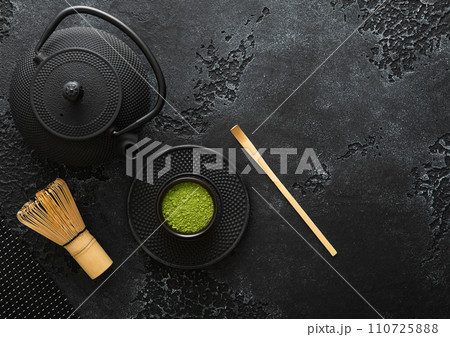 Organic matcha green tea powder with bamboo whisk and spoon and japanese traditional iron kettle Organic matcha green tea powder with bamboo whisk and spoon and japanese traditional iron kettle 110725888