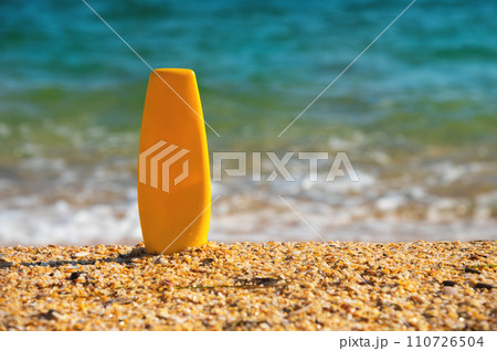 Sunscreen lotion on a tropical beach. Close-up of a tube of moisturizer, space for label or advertising, mockup for perfumery 110726504