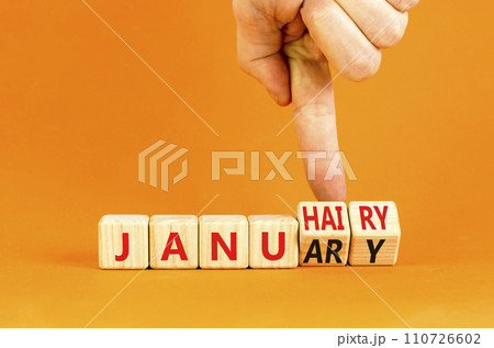 Januhairy or January symbol. Concept words Januhairy or January on beautiful wooden blocks. Beautiful orange table orange background. Man hand. Social issues Januhairy or January concept. Copy space. 110726602