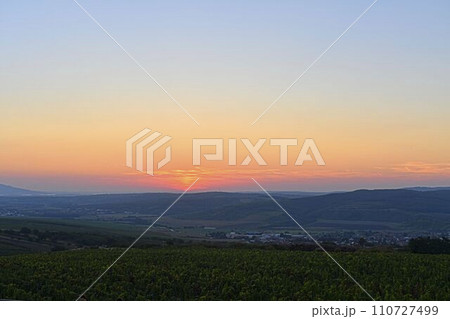 Romantic sunset with the blush of dawn. Twilight with red sky over the landscape. Enchanting sunset with red clouds 110727499