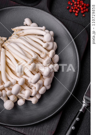 Small white edible beech mushrooms with salt and spices on a plain background 110729858