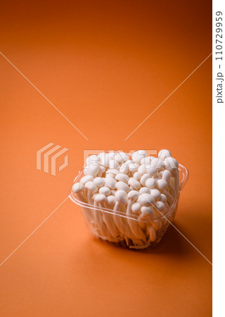 Small white edible beech mushrooms with salt and spices on a plain background 110729959