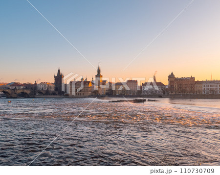 Prague bridge over a river with a city in the background 110730709